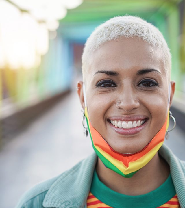 Happy-gay-woman-wearing-LGBT-rainbow-flag-pride-mask